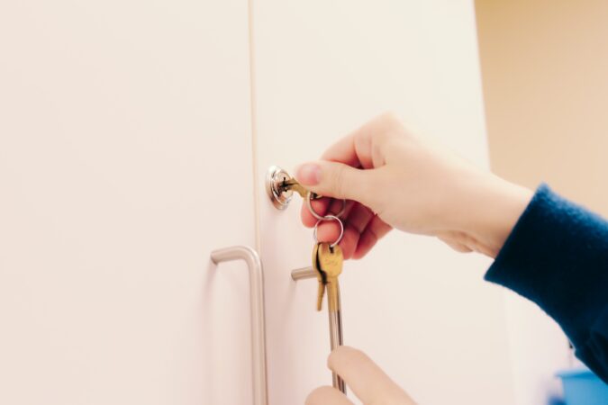 A female locking a cabinet showing us how to childproof your house.