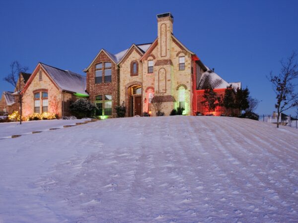 Snow Covered Yard and Stone House.