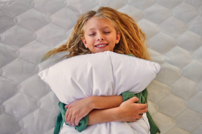 Girl laying with a pillow. A Good Bed And Pillow.