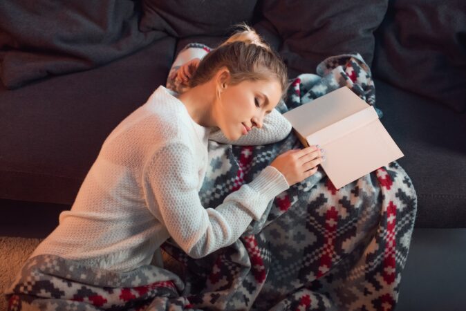 Woman sleeping while studying messing up her sleep pattern.