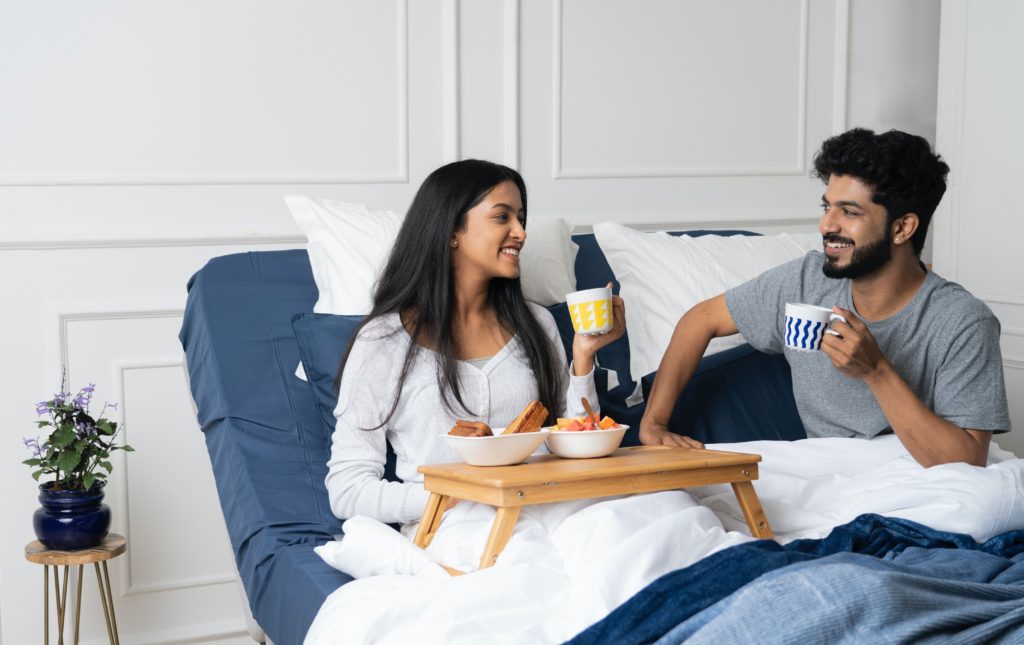 a couple having breakfast in an adjustable bed