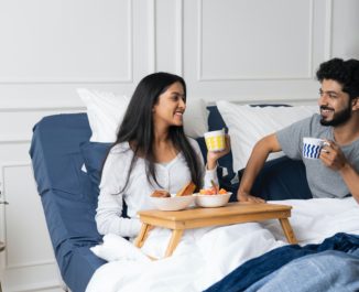 a couple having breakfast in an adjustable bed