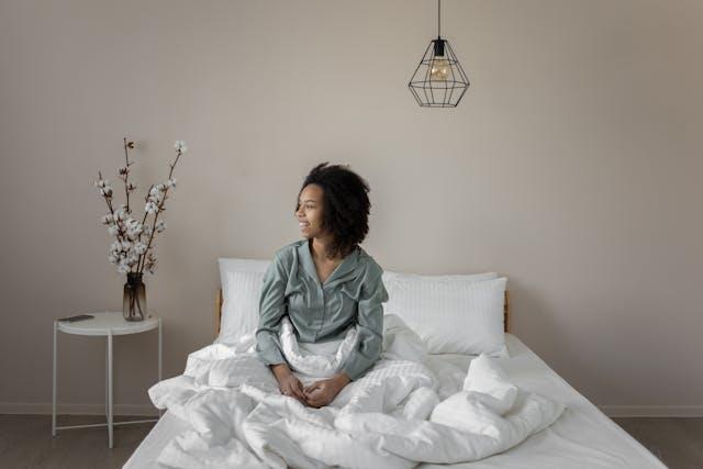 A woman sitting in her bed and smiling