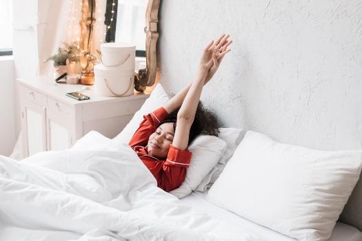 a woman waking up in her bed. poor sleep habits.